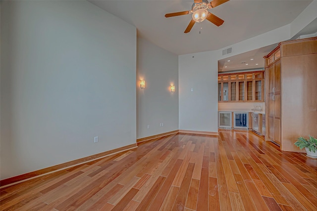 801 E Beach Dr Unit Tw2806, Galveston, TX 77550 - unfurnished living room with wine cooler, ceiling fan, light wood-style flooring, and baseboards