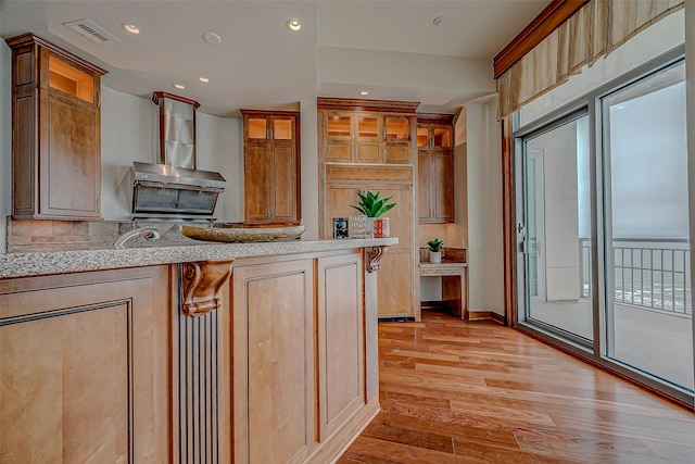 801 E Beach Dr Unit Tw2806, Galveston, TX 77550 - kitchen featuring light wood-type flooring, glass insert cabinets, recessed lighting, tasteful backsplash, and light stone countertops