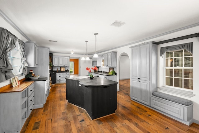 13106 Lookout Mountain Ct, Houston, TX 77069 - kitchen with gray cabinetry, a center island, arched walkways, and dark wood-style floors