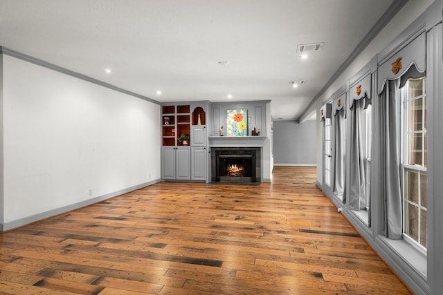 13106 Lookout Mountain Ct, Houston, TX 77069 - unfurnished living room with crown molding, light wood finished floors, recessed lighting, and a lit fireplace