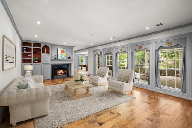 13106 Lookout Mountain Ct, Houston, TX 77069 - living area featuring crown molding, light wood-style flooring, a lit fireplace, and recessed lighting