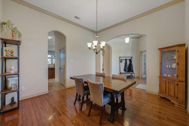 14610 Thunder Bay, Beach City, TX 77523 - dining room with arched walkways, wood finished floors, ornamental molding, a chandelier, and baseboards