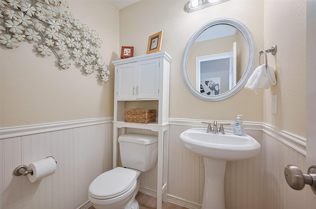 5003 Crystal Wind Ln, Katy, TX 77494 - bathroom with wainscoting, toilet, a decorative wall, and a sink