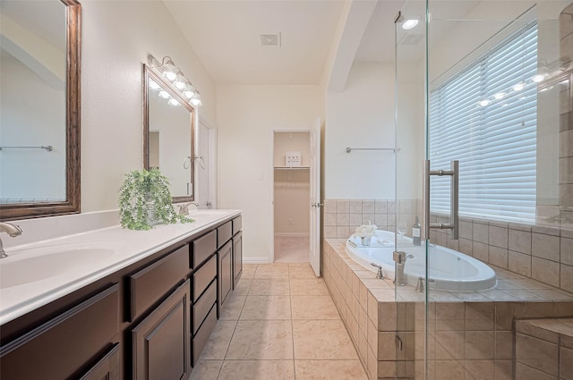 5003 Crystal Wind Ln, Katy, TX 77494 - full bathroom with double vanity, a bath, a stall shower, tile patterned flooring, and baseboards