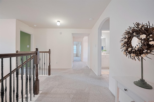5003 Crystal Wind Ln, Katy, TX 77494 - corridor featuring light carpet, an upstairs landing, baseboards, and arched walkways