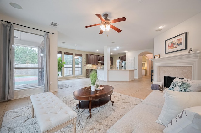 5003 Crystal Wind Ln, Katy, TX 77494 - living room featuring light tile patterned flooring, arched walkways, ceiling fan, baseboards, and recessed lighting