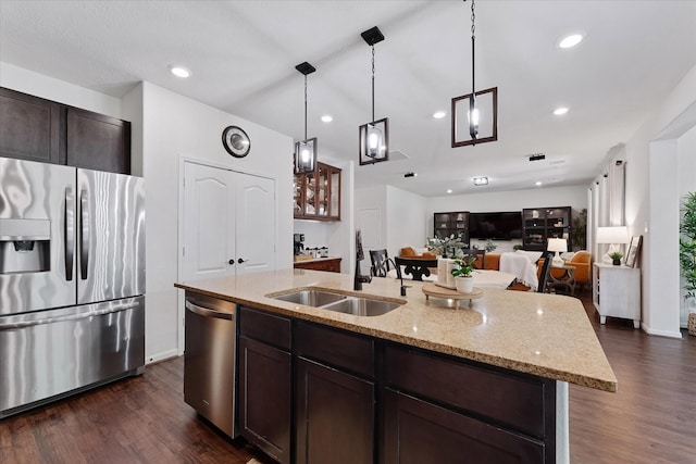 3933 Eagle Nest Lake Ln, Magnolia, TX 77354 - kitchen featuring stainless steel appliances, a sink, dark wood-style floors, dark brown cabinetry, and an island with sink