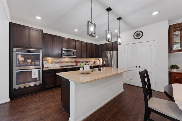 3933 Eagle Nest Lake Ln, Magnolia, TX 77354 - kitchen with appliances with stainless steel finishes, dark brown cabinetry, light stone counters, dark wood-style flooring, and recessed lighting