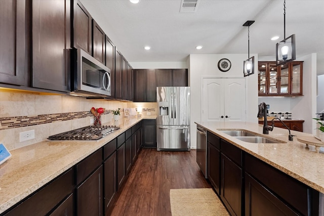 3933 Eagle Nest Lake Ln, Magnolia, TX 77354 - kitchen with stainless steel appliances, a sink, dark wood finished floors, dark brown cabinets, and light stone countertops