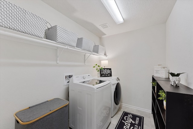 3933 Eagle Nest Lake Ln, Magnolia, TX 77354 - washroom with washer and dryer, baseboards, and light tile patterned flooring