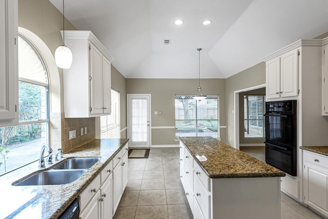 1438 Crescent Green Dr, Houston, TX 77094 - kitchen with a kitchen island, vaulted ceiling, plenty of natural light, light tile patterned floors, and tasteful backsplash