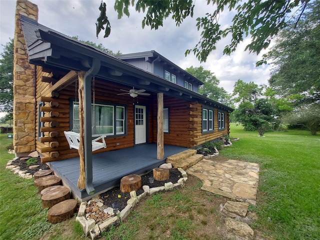 21403 Briar Meadow Rd N, Hempstead, TX 77445 - view of side of property featuring log siding, a ceiling fan, a lawn, and a chimney