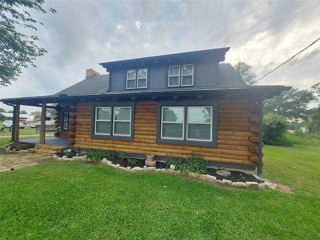 21403 Briar Meadow Rd N, Hempstead, TX 77445 - view of property exterior with log siding, a lawn, and a chimney