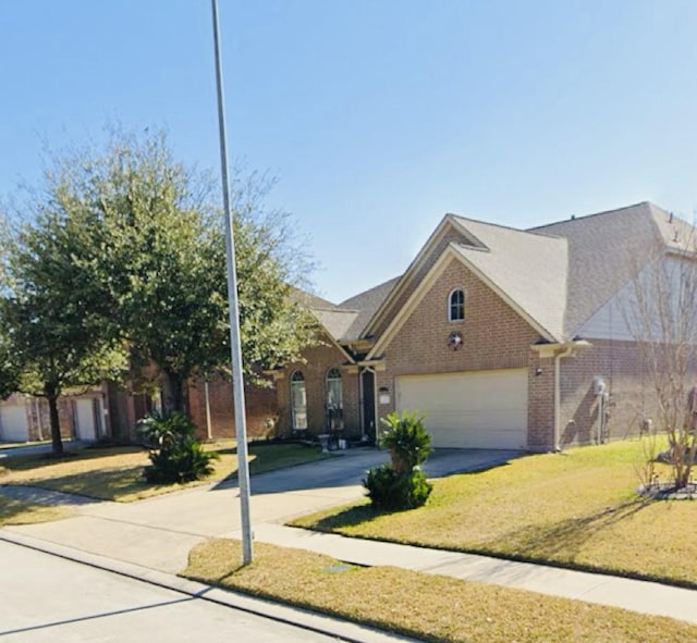 922 N Sky Dr, Houston, TX 77073 - view of front facade with concrete driveway, brick siding, a front yard, and an attached garage