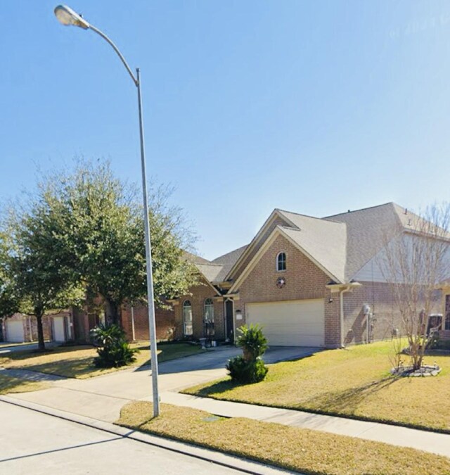 922 N Sky Dr, Houston, TX 77073 - view of front facade featuring brick siding, driveway, a front yard, and an attached garage