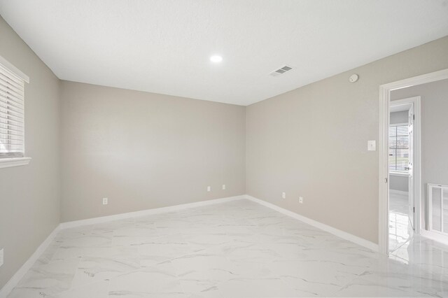 2414 Camillia St, Highlands, TX 77562 - empty room featuring light marble finish flooring, baseboards, and recessed lighting