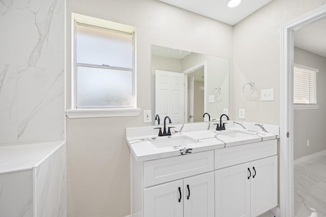 2414 Camillia St, Highlands, TX 77562 - bathroom featuring marble look tiles, double vanity, and baseboards