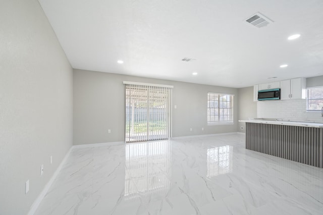 2414 Camillia St, Highlands, TX 77562 - unfurnished living room featuring light marble finish flooring, baseboards, and recessed lighting
