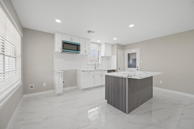 2414 Camillia St, Highlands, TX 77562 - kitchen featuring light marble finish floors, white cabinetry, baseboards, a center island, and recessed lighting