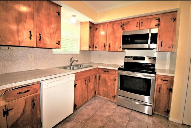 125 Mimosa Pt, Livingston, TX 77351 - kitchen with stainless steel appliances, a sink, crown molding, light countertops, and tasteful backsplash