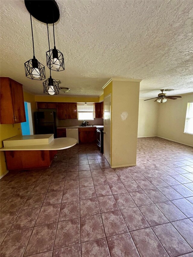 125 Mimosa Pt, Livingston, TX 77351 - kitchen with freestanding refrigerator, plenty of natural light, electric range, a peninsula, and a textured ceiling
