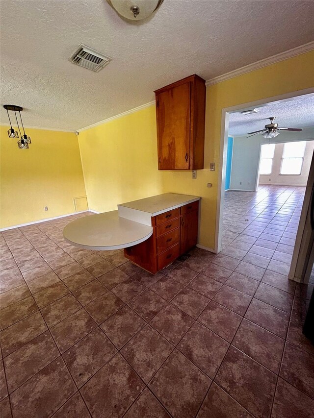 125 Mimosa Pt, Livingston, TX 77351 - kitchen featuring a textured ceiling, crown molding, light countertops, open floor plan, and dark tile patterned flooring