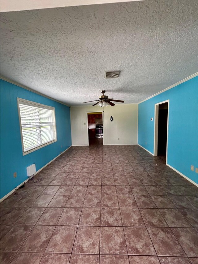 125 Mimosa Pt, Livingston, TX 77351 - spare room with a ceiling fan, tile patterned flooring, a textured ceiling, baseboards, and ornamental molding