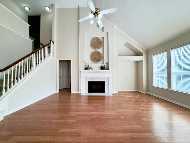 2807 Enchanted Landing Ct, Katy, TX 77494 - unfurnished living room with high vaulted ceiling, ornamental molding, stairway, a ceiling fan, and wood finished floors