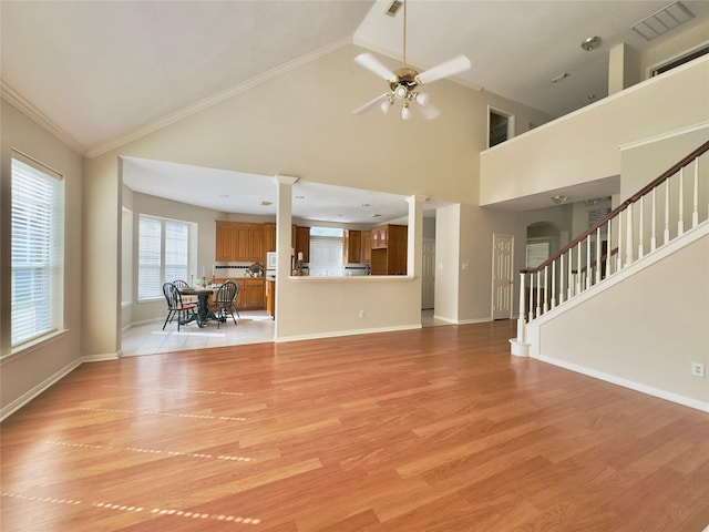 2807 Enchanted Landing Ct, Katy, TX 77494 - unfurnished living room with decorative columns, ceiling fan, light wood-type flooring, stairs, and baseboards