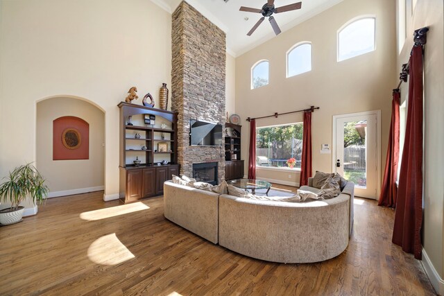 3327 Elmridge St, Houston, TX 77025 - living room with ornamental molding, a fireplace, a towering ceiling, wood finished floors, and baseboards