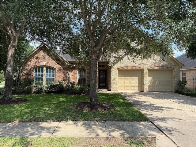 22115 Canyonwood Park Ln, Richmond, TX 77469 - view of property hidden behind natural elements with stone siding, driveway, a garage, a front yard, and brick siding