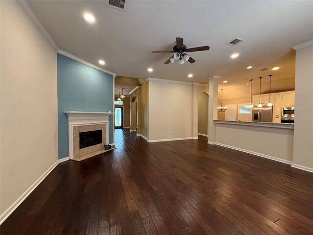 22115 Canyonwood Park Ln, Richmond, TX 77469 - unfurnished living room with ceiling fan, a chandelier, crown molding, a fireplace, and dark wood-style floors