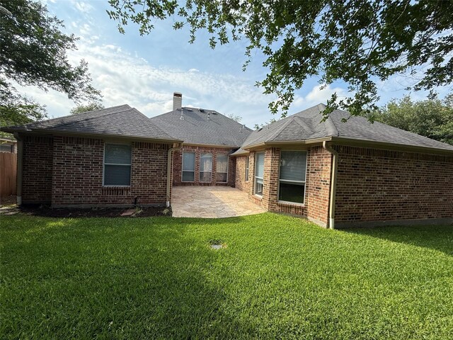 22115 Canyonwood Park Ln, Richmond, TX 77469 - back of house with a patio area, brick siding, a chimney, and a shingled roof