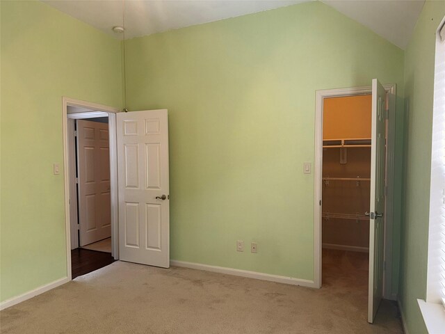 22115 Canyonwood Park Ln, Richmond, TX 77469 - unfurnished bedroom with light carpet, a walk in closet, baseboards, high vaulted ceiling, and a closet