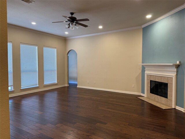 22115 Canyonwood Park Ln, Richmond, TX 77469 - unfurnished living room featuring dark wood-style flooring, a ceiling fan, crown molding, a tiled fireplace, and recessed lighting