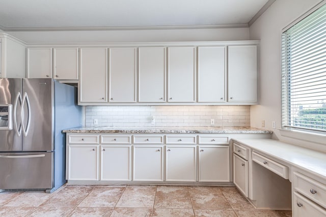 403 Harborside Way, Kemah, TX 77565 - kitchen with stainless steel fridge with ice dispenser, backsplash, light stone countertops, white cabinets, and crown molding