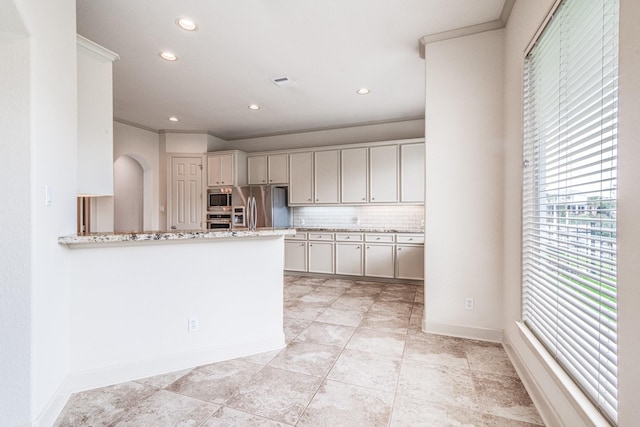 403 Harborside Way, Kemah, TX 77565 - kitchen with stainless steel appliances, light stone counters, backsplash, recessed lighting, and baseboards
