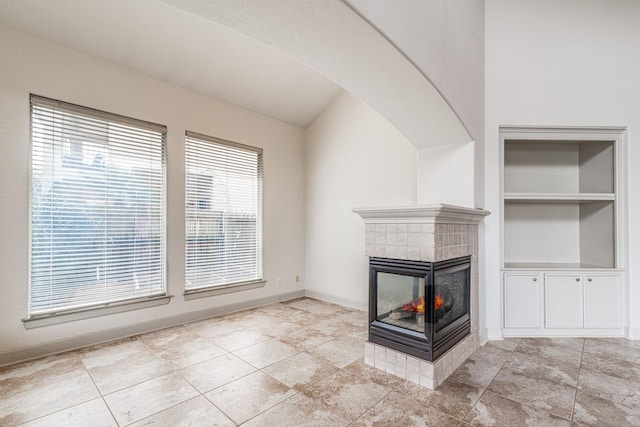 403 Harborside Way, Kemah, TX 77565 - unfurnished living room with a fireplace, built in shelves, baseboards, and vaulted ceiling