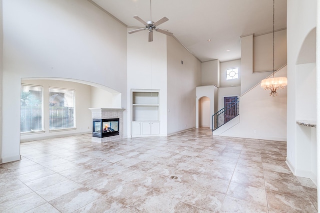 403 Harborside Way, Kemah, TX 77565 - unfurnished living room with built in shelves, high vaulted ceiling, a multi sided fireplace, ceiling fan, and baseboards