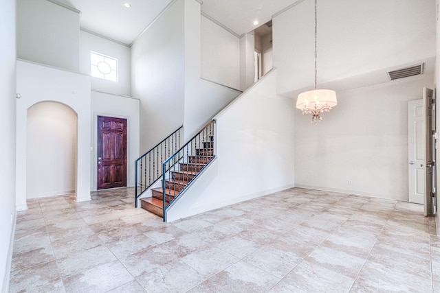 403 Harborside Way, Kemah, TX 77565 - entrance foyer with arched walkways, a chandelier, a towering ceiling, stairs, and baseboards