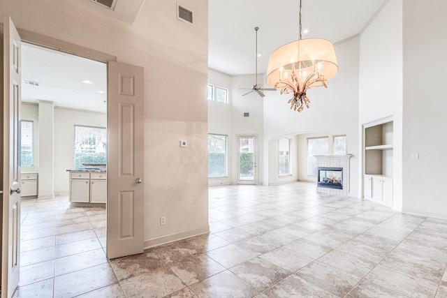 403 Harborside Way, Kemah, TX 77565 - unfurnished living room featuring built in features, a tile fireplace, baseboards, a ceiling fan, and ornamental molding