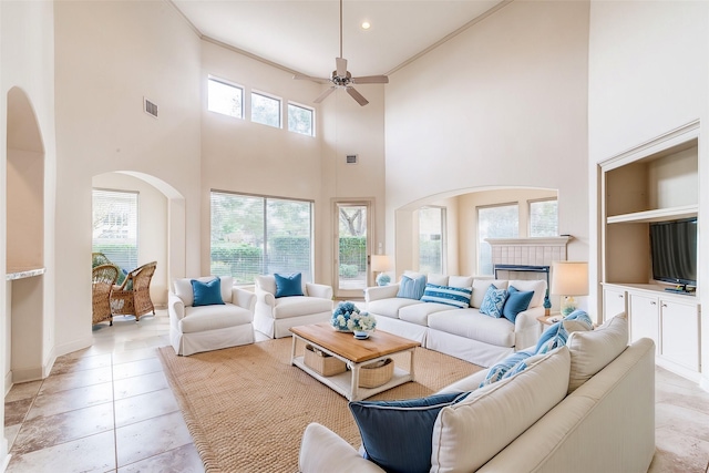 403 Harborside Way, Kemah, TX 77565 - living room with ceiling fan, a towering ceiling, crown molding, a fireplace, and baseboards