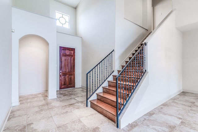 403 Harborside Way, Kemah, TX 77565 - entryway featuring a towering ceiling, stairway, baseboards, arched walkways, and ornamental molding