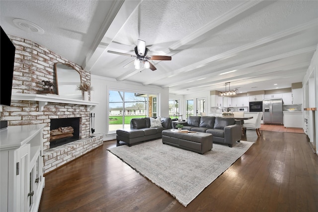 6803 Shady Ln, Richmond, TX 77406 - living room with a textured ceiling, ceiling fan, a brick fireplace, dark wood-type flooring, and beam ceiling