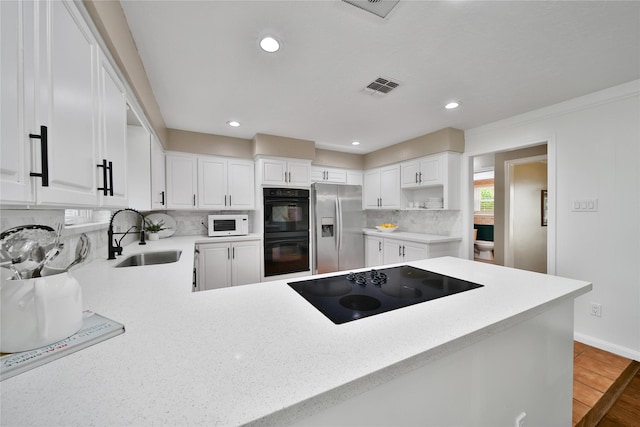 6803 Shady Ln, Richmond, TX 77406 - kitchen with a sink, black appliances, decorative backsplash, open shelves, and white cabinetry