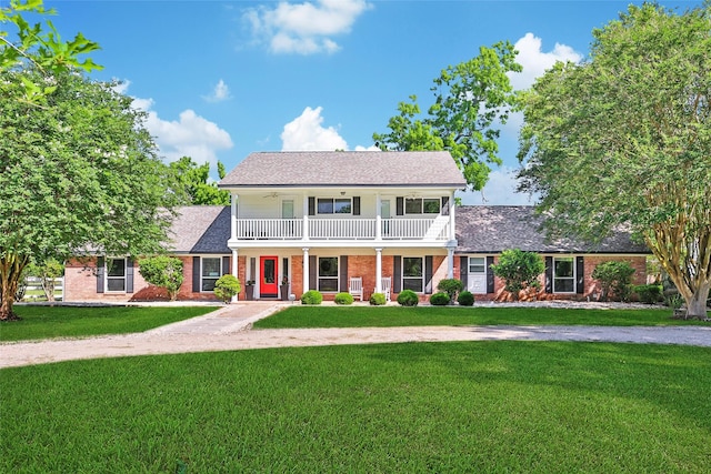 6803 Shady Ln, Richmond, TX 77406 - view of front facade featuring a balcony, brick siding, a front yard, roof with shingles, and a ceiling fan