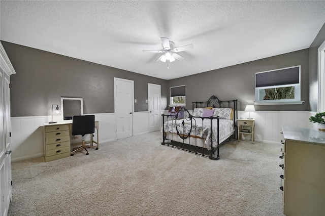 6803 Shady Ln, Richmond, TX 77406 - carpeted bedroom with an office area, a wainscoted wall, a textured ceiling, and ceiling fan