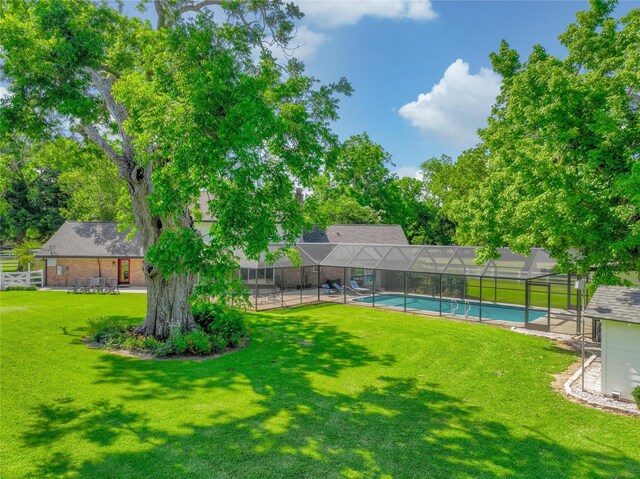 6803 Shady Ln, Richmond, TX 77406 - view of green lawn featuring a patio, glass enclosure, and view of scattered trees
