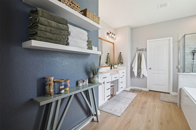 15603 Clearwater Bend Dr, Houston, TX 77044 - bathroom with wood finished floors, vanity, a shower stall, a bathtub, and baseboards