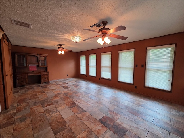 11902 25th St, Santa Fe, TX 77510 - unfurnished living room with a ceiling fan, a textured ceiling, stone finish flooring, and an office area